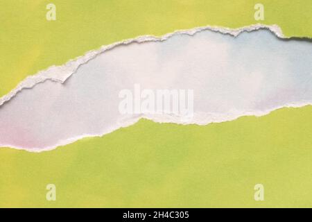 Zerreißtes, zitronengrünes Papier auf blauweißem Himmel Hintergrund. Kopie für Werbefläche. Stockfoto