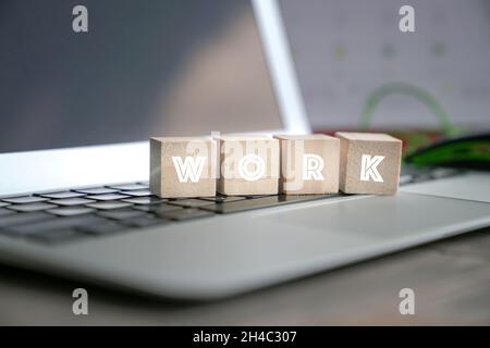 Arbeit, Wort geschrieben auf Holzwürfel auf der Computertastatur. Stockfoto