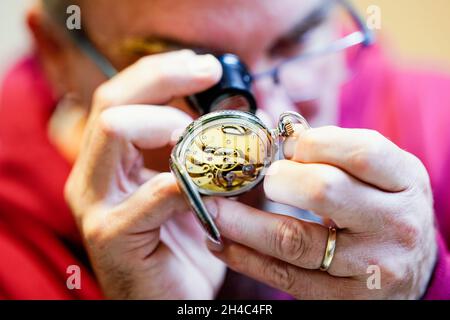 Mannheim, Deutschland. Oktober 2021. Tobias Rackstraw, Gutachter im Pfandhaus, untersucht eine Uhr mit Lupe im Pfandhaus. Wenn das Geld knapp ist, locken Pfandhäuser Kunden mit schnellem Bargeld. (To dpa 'trinkets for money - Pfandhäuser wetten auf Weihnachtsgeschäft') Kredit: Uwe Anspach/dpa/Alamy Live News Stockfoto