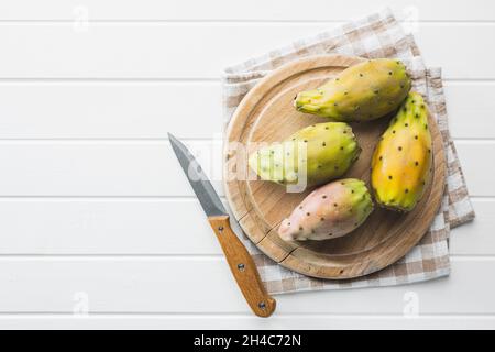 Rohe stachelige Birnen. Opuntia oder indischer Feigenkaktus auf Schneidebrett. Draufsicht. Stockfoto