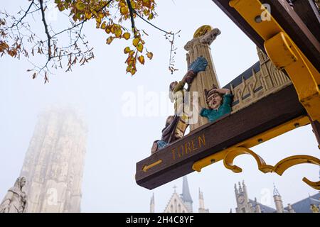 MECHELEN, BELGIEN - 16. Oktober 2021: Ein Schild, das zum Turm von Sint-Rumbolds führt, zeigt die „maneblussers“, den Spitznamen der in Mechelen lebenden Menschen Stockfoto