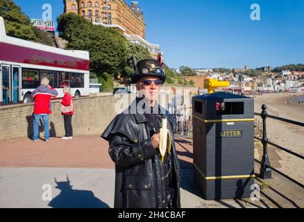 Eine in Steampunk gekleidete morris-Tänzerin, die in Scarborough eine Banane isst Stockfoto