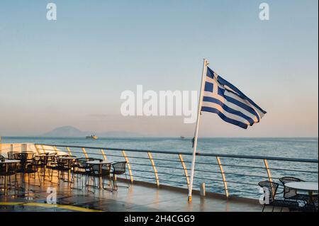 Eine große Fähre im Morgengrauen im Mittelmeer mit einer griechischen Flagge an Bord.Griechenland. Stockfoto