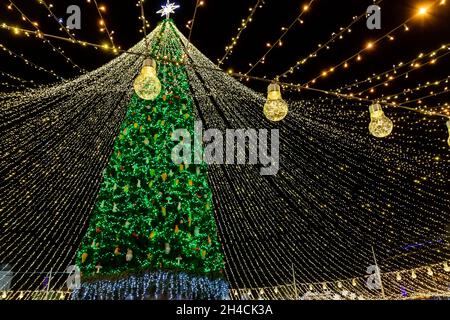 Schöner landschaftlich dekorierter Weihnachtsbaum mit Dekorationen und beleuchtet von hellen Girlanden gegen die Sophia-Kathedrale auf dem Hintergrund Sofievska Platz Stockfoto