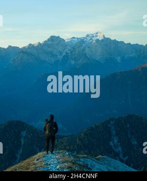 Mann, der vor dem höchsten gipfel der julischen alpen, dem Triglav, steht. Die Alpen anbeten. Alpen Hintergrund. Hintergrund der Berglandschaft Stockfoto