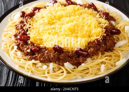 Cincinnati Stil Chili 5 Way Nahaufnahme in der Platte auf dem schwarzen Holzhintergrund. Horizontal Stockfoto