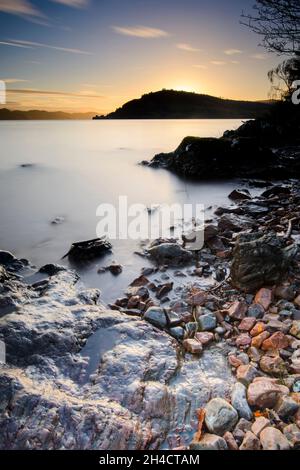 Sonnenuntergang über Urquhart Castle vom Ufer des Loch Ness, Schottland Stockfoto