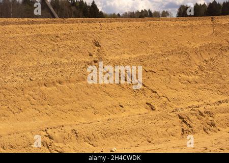 Sandplattform. Sand in die Basis legen. Viel Baumaterial. Bau einer Straßenkreuzung. Stockfoto