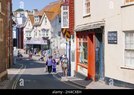 Menschen tragen Shopping und zu Fuß entlang der Bridge Street Stadtzentrum Lyme Regis Dorset England GB Europa Stockfoto