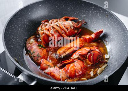 Kochen von rohem Hummer in einer tiefen Bratpfanne Stockfoto