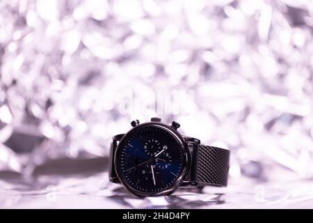 Schwarze Metallarmbanduhr mit dunklen Zifferblättern vor einem klar beleuchteten Hintergrund. Hochwertige Fotos Stockfoto