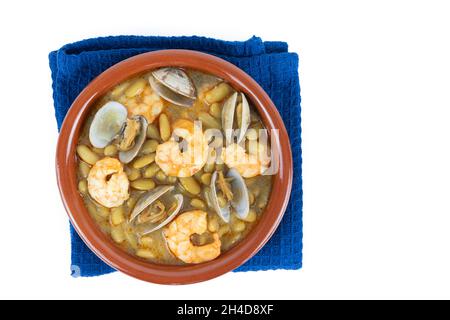 Grüne Bohnen mit Garnelen und Venusmuscheln in Steingutauflauf auf weißem Hintergrund. Kopierbereich, Draufsicht. Stockfoto