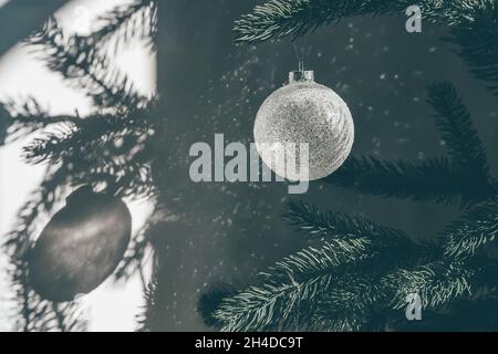 Glänzende Glitzerglas Weihnachtskugel gegen Sonnenstrahlen Stockfoto