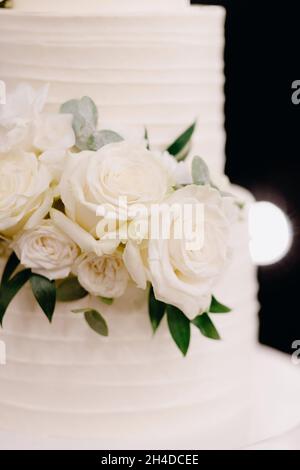 Weiße Rosen in Hochzeitstorte Stockfoto