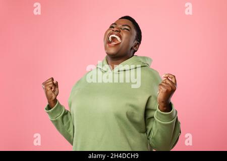 Emotionale Überdimensionale Afrikanische Frau, Die Auf Rosa Hintergrund Ja Schreit Stockfoto