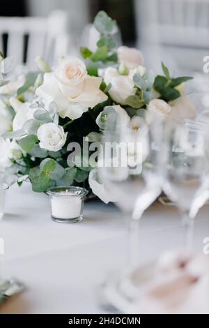 Komposition mit weißen Rosen auf einem grauen Tisch. Hochzeitsdekor Stockfoto