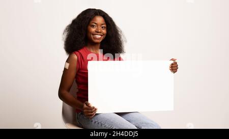 Werbung Für Impfkampagnen Geimpfte Schwarze Frau, Die Einen Leeren Schrank In Den Händen Hält Stockfoto