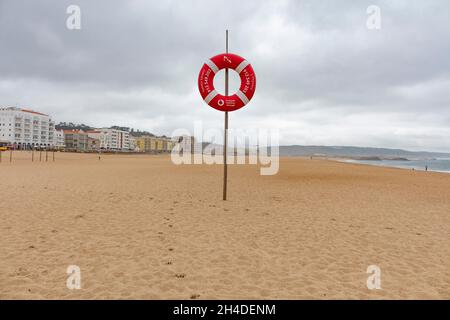 Leerer Strand von Nazaré in Portugal. Rettungsring am Strand zur Sicherheit Stockfoto