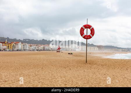 Leerer Strand von Nazaré in Portugal. Rettungsring am Strand zur Sicherheit Stockfoto