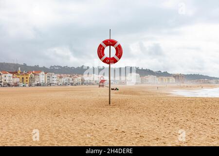 Leerer Strand von Nazaré in Portugal. Rettungsring am Strand zur Sicherheit Stockfoto