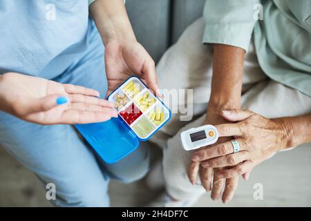 Nahaufnahme einer nicht erkennbaren Krankenschwester, die eine ältere Frau im Altersheim konsultiert, Kopierraum Stockfoto