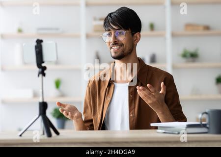 Lächelnder arabischer Mann mit Brille Vlogger, der von zu Hause aus sendet Stockfoto