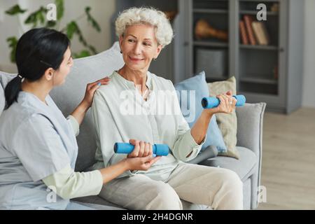 Porträt einer Krankenschwester, die älteren Frauen bei der Ausbildung im Altersheim hilft Stockfoto