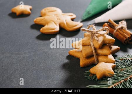 Weihnachts-Lebkuchenkekse, fertig zum Verzieren mit Glasur, aromatischen Nelken, Ingwer, Zimt und reichem schwarzen Baumkehlchen. Nahaufnahme auf dem Tisch. Stars und Stockfoto