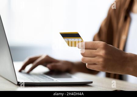 Nicht erkennbarer Mann, der im Büro im Internet einkauft Stockfoto