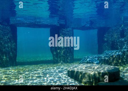 Eine Steinsäule unter blauem Wasser Stockfoto