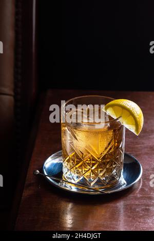 Whiskey- und Soda-Cocktail-Drink On The Rocks mit Zitronenhack in der luxuriösen dunklen Bar Stockfoto