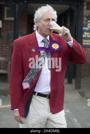 Ein UKIP-Anhänger genießt einen Kaffee vor dem Racing Greyhound Pub in Ramsgate, South Thanet, während er vor der Wahlkampfstrecke für die Parlamentswahlen auf Anführer Nigel Farage an einem Aktionstag in Ramsgate wartet. Stockfoto