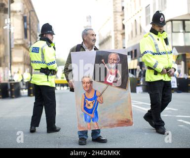 Der politische Künstler Kaya Mar steht auf der Conservative Party Conference 2015 in Manchester Central mit einem seiner satirischen Gemälde vor dem Convention Center. Stockfoto