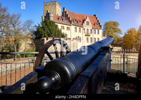 Halberstadt, 28. Oktober 2021: Blick über eine historische Eisenkanone auf die Fassade des Wasserschlosses Flechtingen Stockfoto