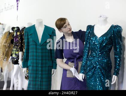 Die Auktionsassistentin Lucy Bishop bringt den letzten Schliff an zwei Kleidern von Prinzessin Diana, beide in Blautönen/Grün, im Rahmen der Auktion Passion for Fashion am 14. Juni bei Kerry Taylor Auctions im Süden Londons. (Links) Los 208, ein praktischer großer Tartan-Karo mit breiten gepolsterten Schultern mit Dianas markentworfenem Matrosenkragen, entworfen von Elizabeth und David Emanuel, Schätzung £10,000-15,000. (Rechts) Los 210, ein glamouröses Kleid, das von der Designerin Catherine Walker bis zum Knie gespalten wurde, Schätzung: £80,000-100,000. Stockfoto