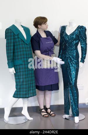 Die Auktionsassistentin Lucy Bishop bringt den letzten Schliff an zwei Kleidern von Prinzessin Diana, beide in Blautönen/Grün, im Rahmen der Auktion Passion for Fashion am 14. Juni bei Kerry Taylor Auctions im Süden Londons. (Links) Los 208, ein praktischer großer Tartan-Karo mit breiten gepolsterten Schultern mit Dianas markentworfenem Matrosenkragen, entworfen von Elizabeth und David Emanuel, Schätzung £10,000-15,000. (Rechts) Los 210, ein glamouröses Kleid, das von der Designerin Catherine Walker bis zum Knie gespalten wurde, Schätzung: £80,000-100,000. Stockfoto