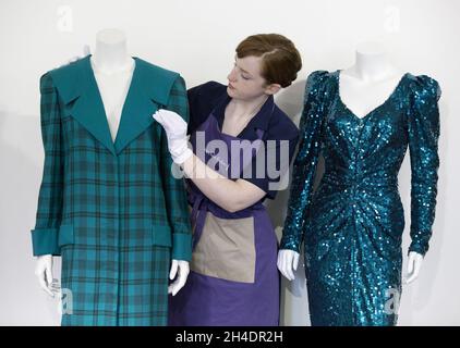 Die Auktionsassistentin Lucy Bishop bringt den letzten Schliff an zwei Kleidern von Prinzessin Diana, beide in Blautönen/Grün, im Rahmen der Auktion Passion for Fashion am 14. Juni bei Kerry Taylor Auctions im Süden Londons. (Links) Los 208, ein praktischer großer Tartan-Karo mit breiten gepolsterten Schultern mit Dianas markentworfenem Matrosenkragen, entworfen von Elizabeth und David Emanuel, Schätzung £10,000-15,000. (Rechts) Los 210, ein glamouröses Kleid, das von der Designerin Catherine Walker bis zum Knie gespalten wurde, Schätzung: £80,000-100,000. Stockfoto