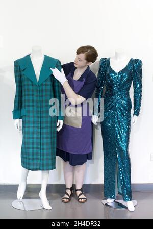 Die Auktionsassistentin Lucy Bishop bringt den letzten Schliff an zwei Kleidern von Prinzessin Diana, beide in Blautönen/Grün, im Rahmen der Auktion Passion for Fashion am 14. Juni bei Kerry Taylor Auctions im Süden Londons. (Links) Los 208, ein praktischer großer Tartan-Karo mit breiten gepolsterten Schultern mit Dianas markentworfenem Matrosenkragen, entworfen von Elizabeth und David Emanuel, Schätzung £10,000-15,000. (Rechts) Los 210, ein glamouröses Kleid, das von der Designerin Catherine Walker bis zum Knie gespalten wurde, Schätzung: £80,000-100,000. Stockfoto