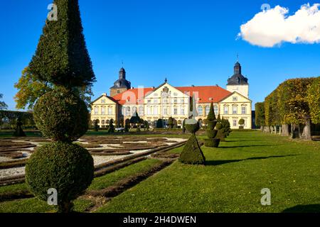 Halberstadt, 28. Oktober 2021: Blick über kunstvoll getrimmte und geschnitzte Buxenbäume in einem Barockgarten auf das Schloss Hundisburg Stockfoto
