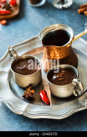 Zwei Tassen scharfe mexikanische oder spanische dicke heiße Schokolade mit Chiles und Zutaten Stockfoto