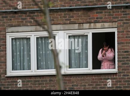 Ein Nachbar gegenüber dem Whittington Hospital im Norden Londons, schließt sich dem Applaus an, um lokale Helden während des landesweiten Clap for Carers zu begrüßen, um NHS-Mitarbeiter und Betreuer, die die Coronavirus-Pandemie bekämpfen, zu erkennen und zu unterstützen. Bilddatum: Donnerstag, 30. April 2020. Stockfoto