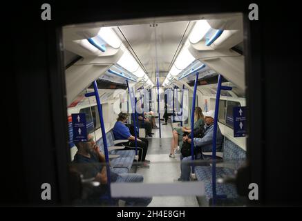 Pendler, die eine Gesichtsmaske tragen, während sie in einem U-Bahn-Zug der Piccadilly Line in London unterwegs sind, während die Regierung beginnt, einige Sperrmaßnahmen in England zu lockern. Bilddatum: Montag, 1. Juni 2020. Stockfoto