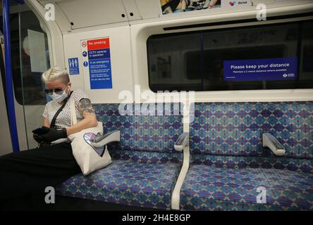 Ein Pendler, der eine Gesichtsmaske trägt, hält die soziale Distanz aufrecht, während er in einem U-Bahnhof der Piccadilly-Linie in London unterwegs ist, während die Regierung beginnt, einige Lockerungen in England zu ergreifen. Bilddatum: Montag, 1. Juni 2020. Stockfoto