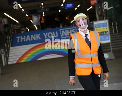 Ein Arbeiter, der ein Visier als persönliche Schutzausrüstung trägt, steht vor der Cannon Street in London, wo auf den Stufen des Bahnhofs ein Regenbogen gezeigt wurde, um der Arbeit des britischen NHS (National Health Service) zu danken, während die Regierung beginnt, einige Sperrmaßnahmen in England zu lockern. Bilddatum: Montag, 1. Juni 2020. Stockfoto