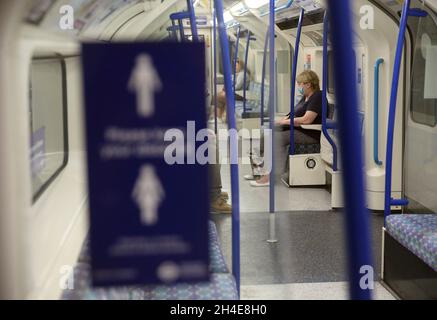 Ein Pendler, der eine Gesichtsmaske trägt, während er in einem U-Bahn-Zug der Piccadilly Line in London unterwegs ist, während die Regierung beginnt, einige Sperrmaßnahmen in England zu lockern. Bilddatum: Montag, 1. Juni 2020. Stockfoto