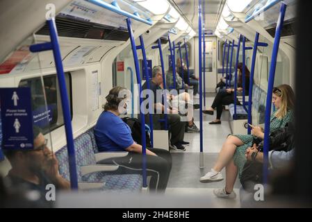 Pendler, die eine Gesichtsmaske tragen, während sie in einem U-Bahn-Zug der Piccadilly Line in London unterwegs sind, während die Regierung beginnt, einige Sperrmaßnahmen in England zu lockern. Bilddatum: Montag, 1. Juni 2020. Stockfoto
