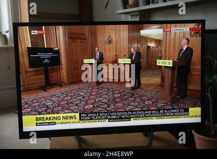 Ein Fernseher in einem Haus im Norden Londons zeigt (von links nach rechts) den wissenschaftlichen Chefberater Sir Patrick Vallance, den Premierminister Boris Johnson und den britischen Chief Medical Officer Chris Whitty während der täglichen Medienbesprechung mit dem Coronavirus, während die Regierung Pläne ankündigt, die Sperrbeschränkungen in England weiter zu lockern. Bilddatum: Mittwoch, 10. Juni 2020. Stockfoto