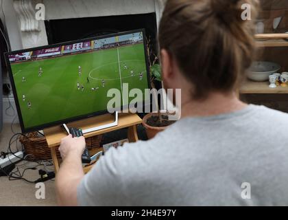 Ein Fußballfan im Norden Londons sieht sich das Spiel der Aston Villa gegen Sheffield United Premier League im Fernsehen an. Die Premier League kehrte am Mittwoch hinter verschlossenen Türen zurück, da weitere Beschränkungen für die Sperrung des Coronavirus in England aufgehoben wurden. Bilddatum: Mittwoch, 17. Juni 2020. Stockfoto