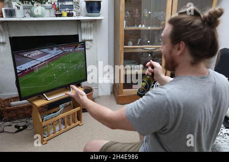 Ein Fußballfan im Norden Londons sieht sich das Spiel der Aston Villa gegen Sheffield United Premier League im Fernsehen an. Die Premier League kehrte am Mittwoch hinter verschlossenen Türen zurück, da weitere Beschränkungen für die Sperrung des Coronavirus in England aufgehoben wurden. Bilddatum: Mittwoch, 17. Juni 2020. Stockfoto