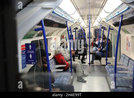 Pendler, die eine Gesichtsmaske tragen, während sie in einer U-Bahn der Piccadilly Line in London unterwegs sind, da Gesichtsbedeckungen in den öffentlichen Verkehrsmitteln in England obligatorisch werden. Bilddatum: Donnerstag, 18. Juni 2020. Stockfoto